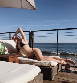 McKenna Berkley tanning in black bikini