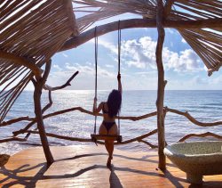 Nicole Scherzinger in thong bikini on a beach swing
